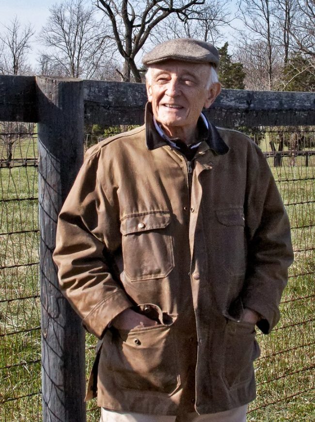 Norman Fine portrait in front of horse fence